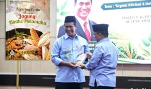 Rektor IAIN Sultan Amai Gorontalo, Prof. Dr. Ahmad Faisal, M.Ag., menyerahkan buku “Sepiring Cerita Bersama Jagung–Binthe Molamahu” kepada Menteri Pertanian RI, Dr. Ir. H. Andi Amran Sulaiman, M.P., usai kegiatan Silaturahmi dan Tausiyah Swasembada Pangan di Kampus IAIN Sultan Amai Gorontalo. (Foto: Annahdlah)